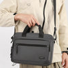 A gray Oxford cloth crossbody briefcase with a laptop compartment is shown being held by a person.