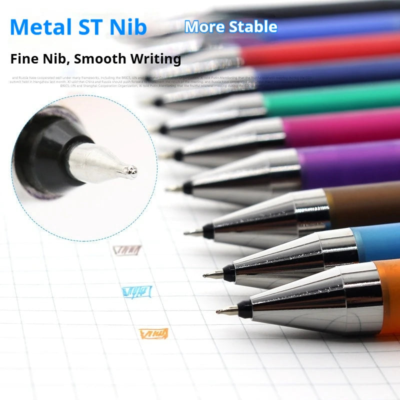 A collection of metal ST nib pens in various colors and angles resting on a white grid paper.