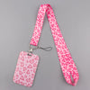 A pink heart-patterned lanyard with a tag is displayed against a gray background.