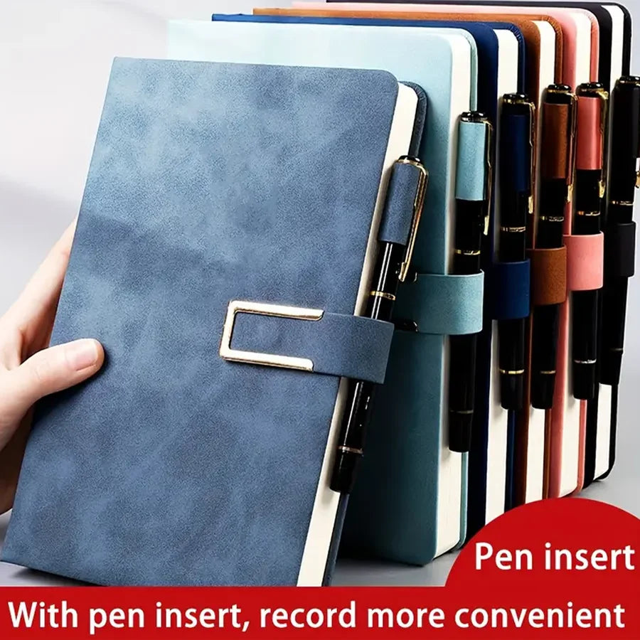 A stack of colorful notebooks with a blue cover and a pen insert shown next to a hand.