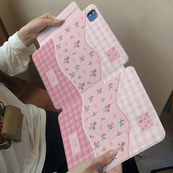A pink floral print magnetic iPad case with a stand is shown being held by a hand.