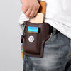 A brown leather waist bag is shown attached to a person's jeans, holding a smartphone and keys.