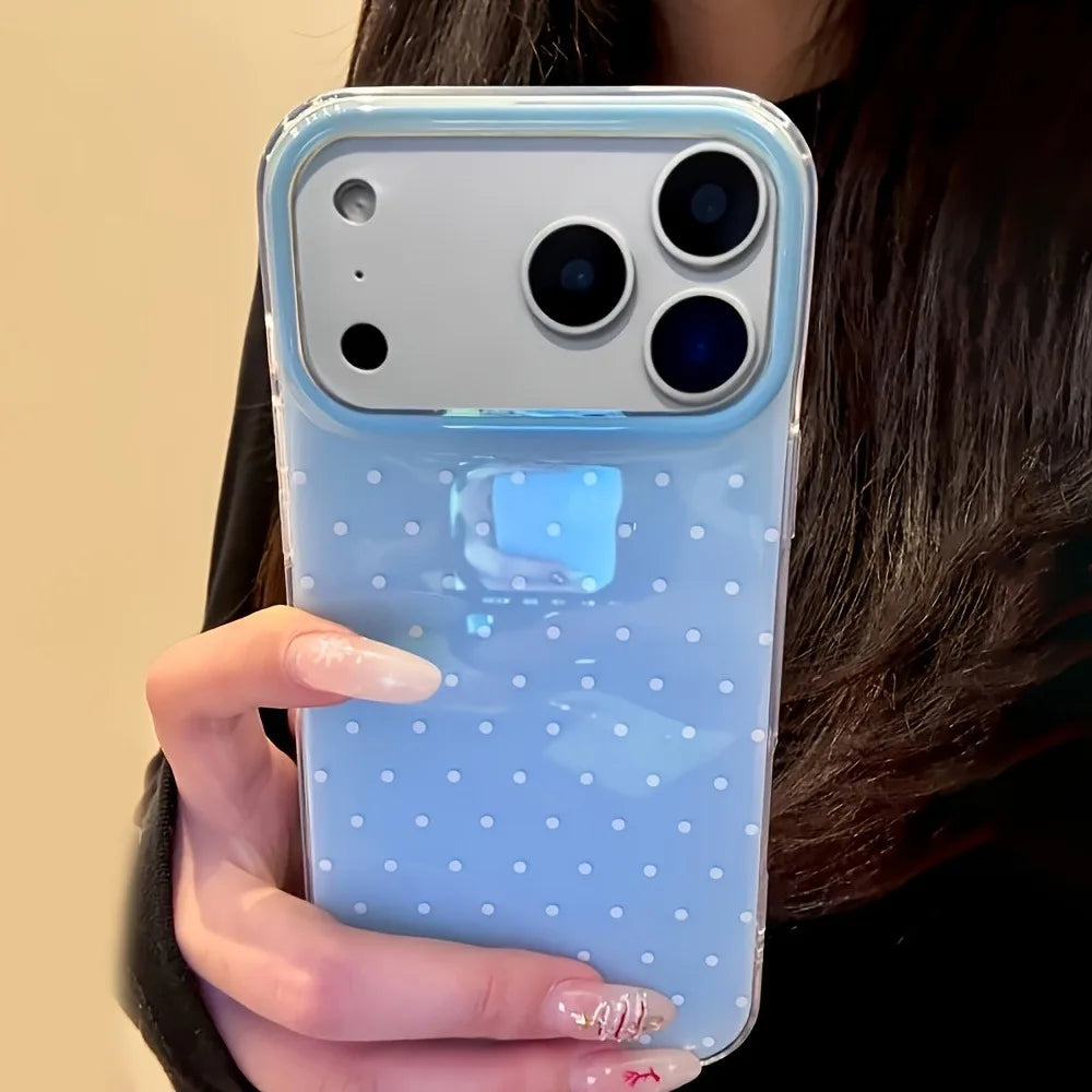 A hand holds a light blue polka dot shockproof phone case with a clear back and multiple camera lenses.