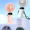 Cuatro mini ventiladores portátiles de colores exhibidos en pedestales blancos contra un cielo azul claro.