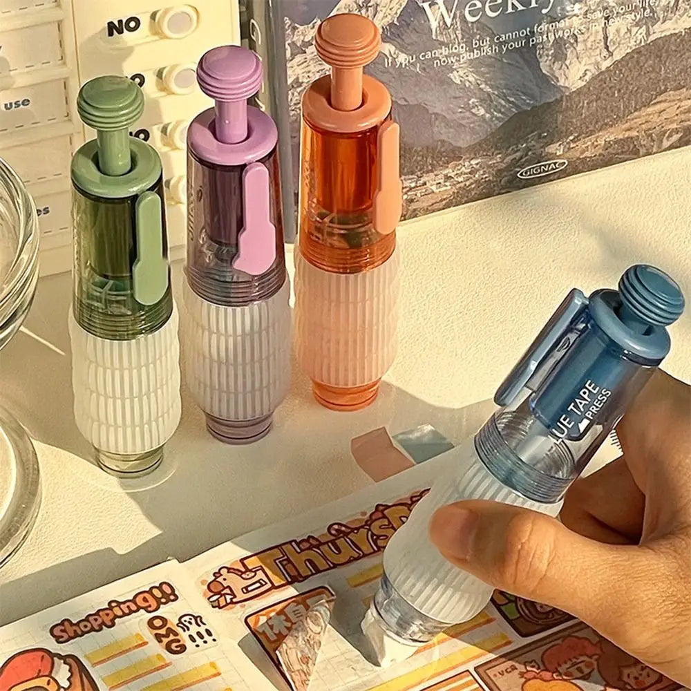 A hand holds a blue glue pen next to several colored glass bottles of double sided quick dry dot glue.
