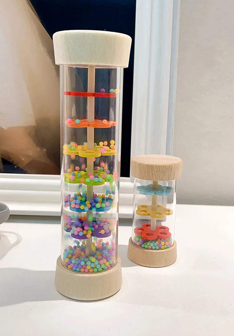 A wooden rain sound tube musical instrument filled with colorful plastic beads and tubes.