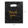 Black gift bag with gold script text that reads Thank you