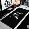 A black extra large gaming mouse pad featuring a white silhouette of a wolf head and paws, displayed on a desk.