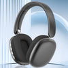A pair of matte gray wireless over-ear headphones resting on a glass surface.