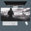 A large gaming mousepad featuring a silhouette of Miyamoto Musashi from the Vagabond manga, placed under a computer monitor.