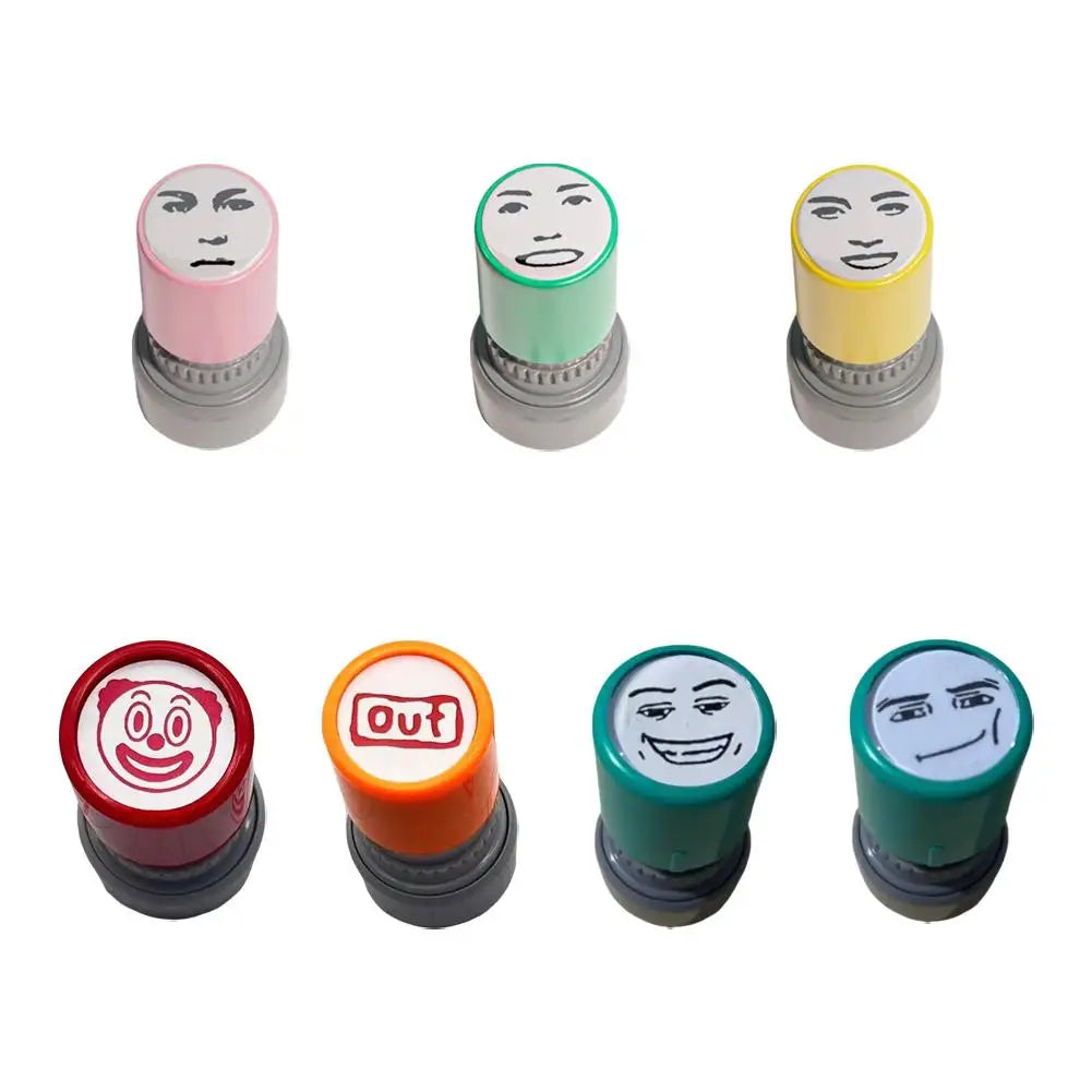 A set of five self-inking rubber stamps featuring various funny meme faces in pink, green, yellow, red, and dark green.