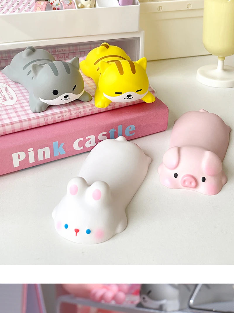 A collection of pink and yellow kawaii ergonomic wrist rests shaped like cats and pigs are displayed on a white surface.