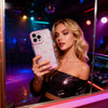 A woman holds an iPhone in a reflective mirror, showcasing the LED Bowknot Glow Case.