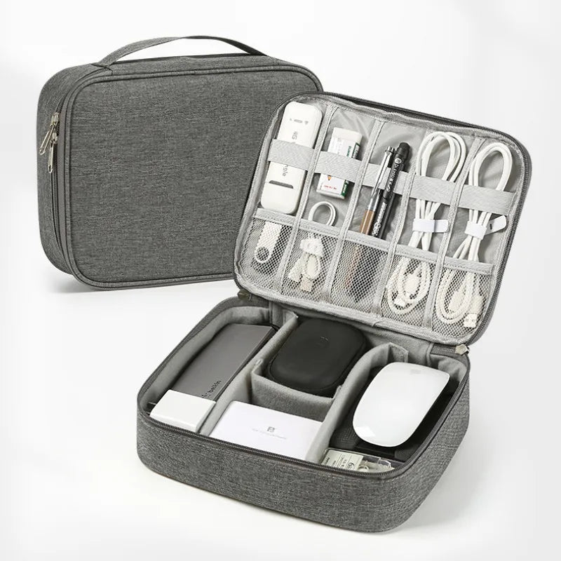 A gray travel cable organizer bag with an open compartment showing various electronic cables and accessories.