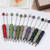 A collection of 20 rhinestone beaded pen accessories in various shades of green, purple, and silver.