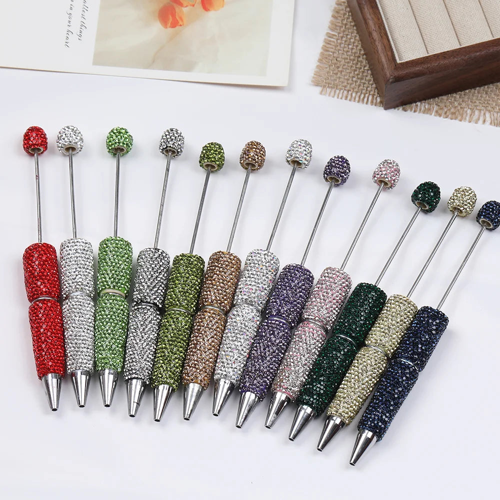 A collection of 20 rhinestone beaded pen accessories in various shades of green, purple, and silver.