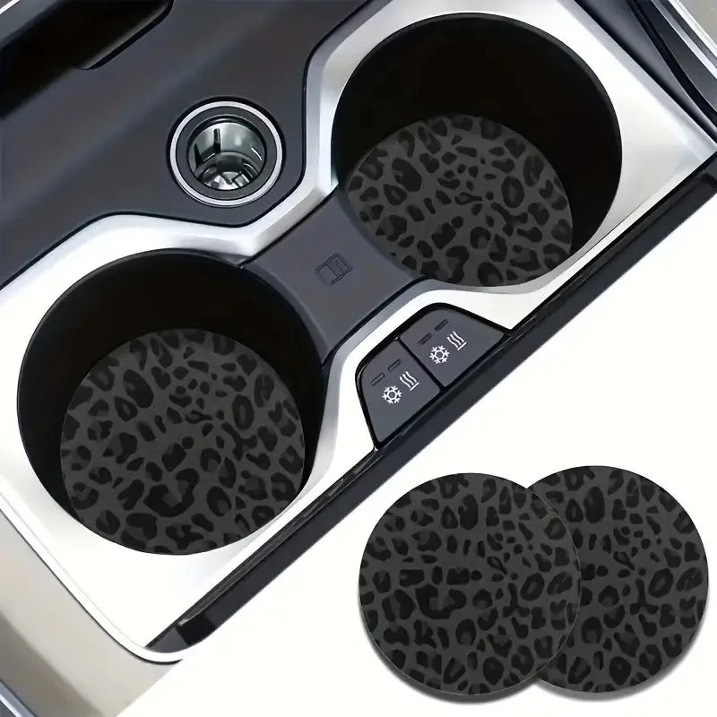 A set of two non-slip leather car cup holder coasters with leopard print designs.