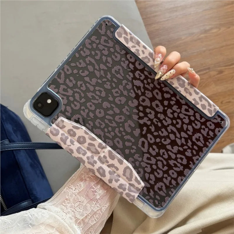 A hand holds a leopard print leather case for an iPad against a light background.