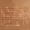 A set of blue sea themed PBT keycaps for a mechanical keyboard displayed on a wooden surface.
