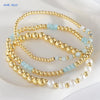 Gold-plated shell pearl beaded bracelets in various shades of blue and white displayed on a white background.