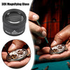 A black 30X magnifying glass is shown being used to inspect jewelry and coins.