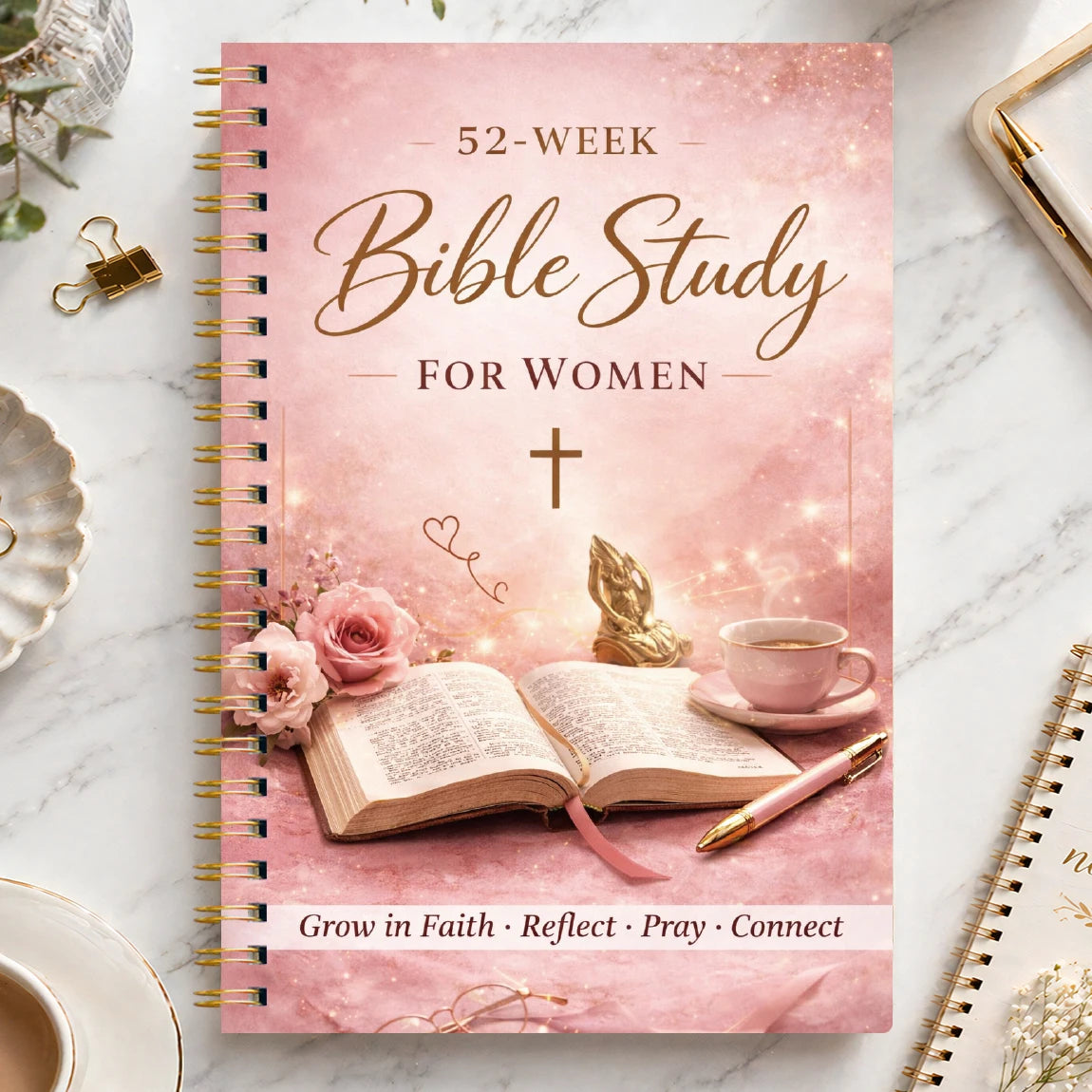 A pink spiral-bound journal titled 52-Week Bible Study for Women featuring a cross and floral accents.