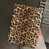 A close-up of a leopard print protective skin for an iPad case being held by a hand.