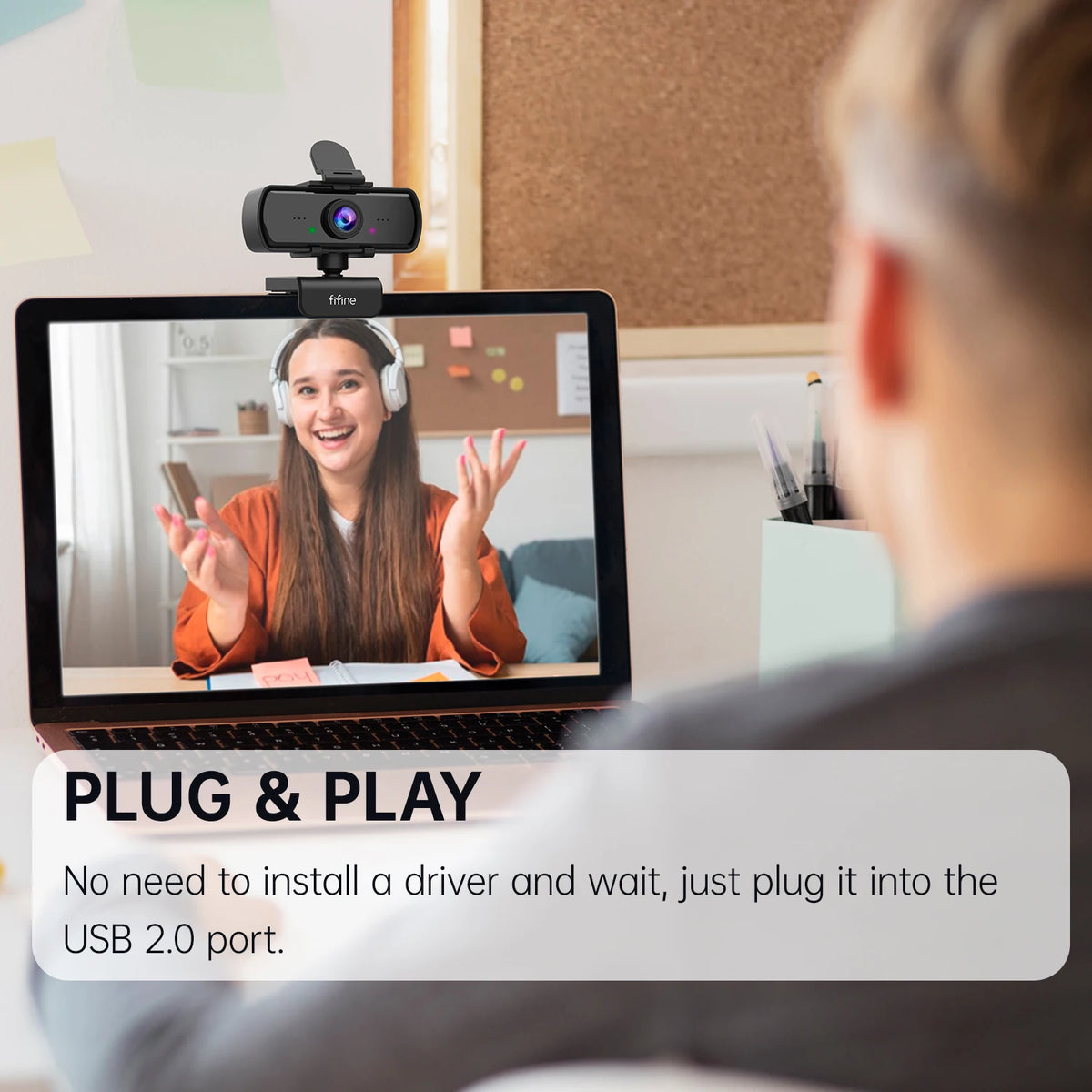 A person is using a plug and play webcam connected to a laptop, showing a video call on the screen.