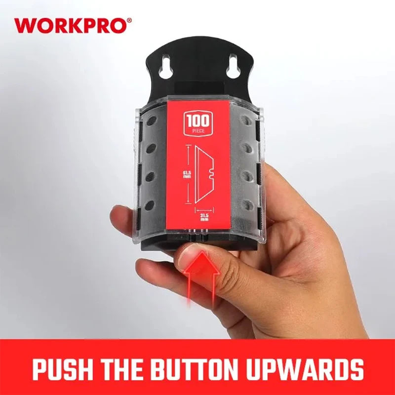 Une main pousse un bouton vers le haut sur un emballage de lame de couteau utilitaire noir pour un set de 100 pièces.