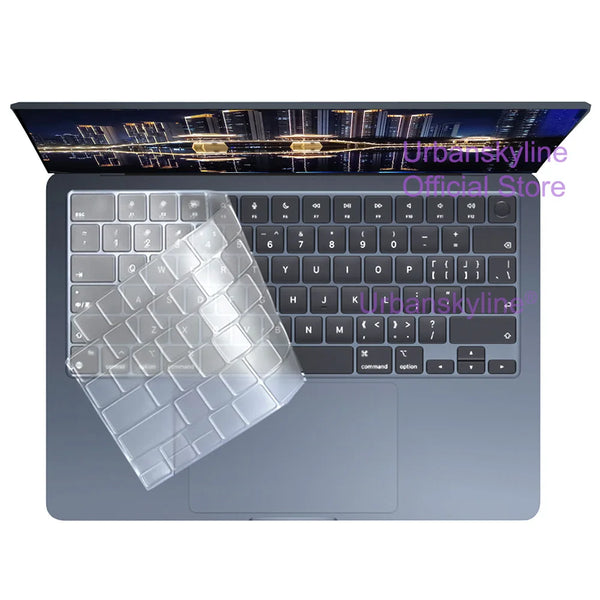 A laptop with a clear silicone keyboard cover is shown, displaying a cityscape on the screen.