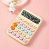 A beige mechanical 12-digit calculator with large round keys is shown on a pink background.