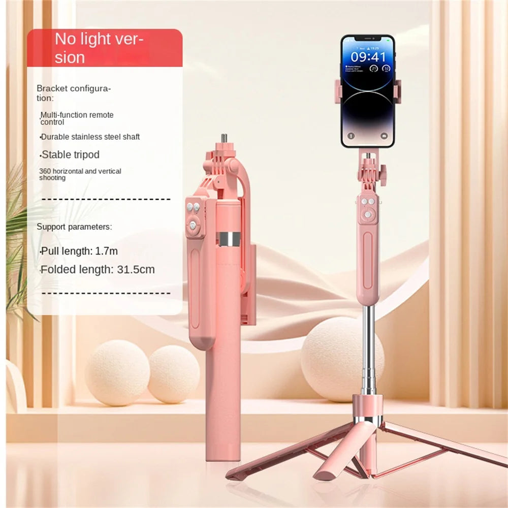 A pink 360 degree rotation selfie stick with a smartphone attached, shown next to its instruction manual.