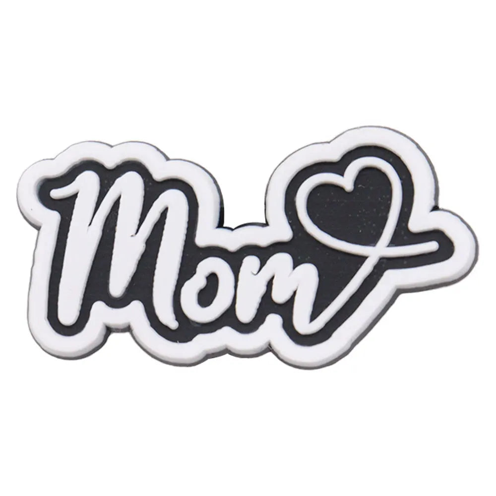 A black and white die-cut charm shaped like the word Mom with a heart design.