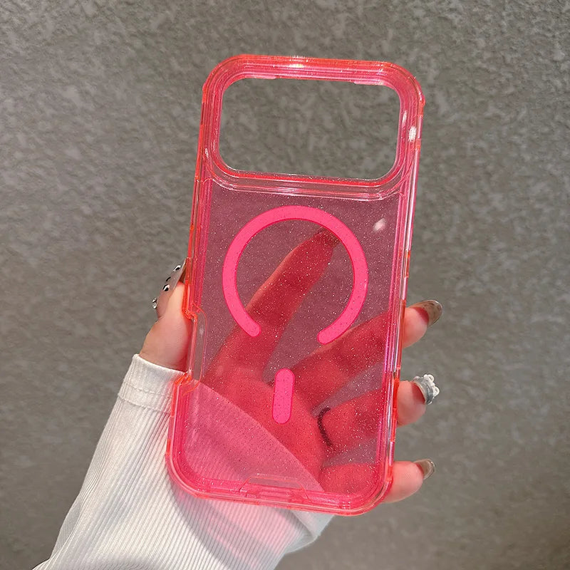 A hand holds a clear pink glitter shockproof magnetic case for an iPhone with a circular cutout.