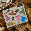 A collection of vintage metal clip themed stickers for journaling and scrapbooking displayed on a white card.