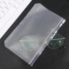 A clear PVC zipper binder pocket containing eyeglasses and other small items on a dark surface.