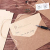 A set of vintage European style letter and invitation envelopes tied with twine on a wooden surface.