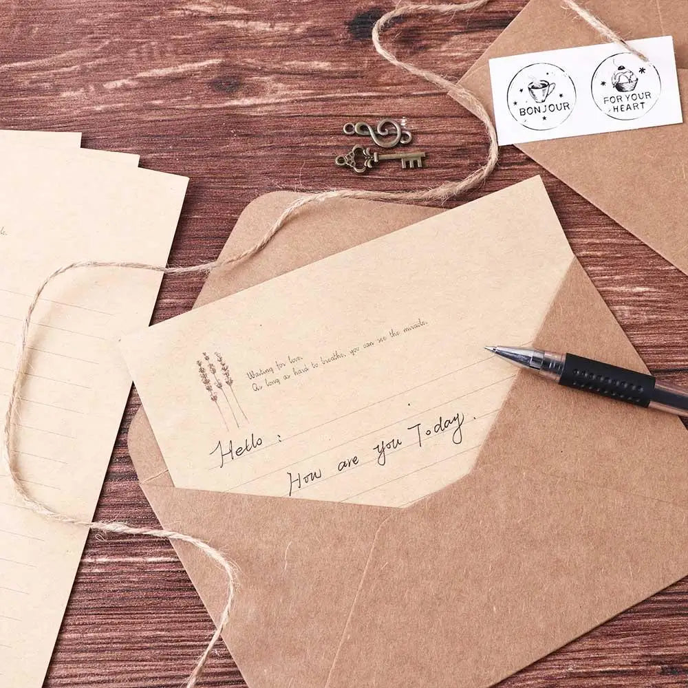 A set of vintage European style letter and invitation envelopes tied with twine on a wooden surface.