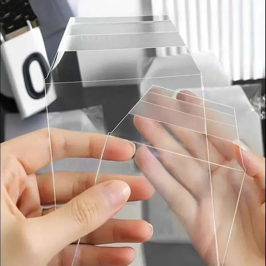 Manos colocando fundas magnéticas transparentes sobre una foto o tarjeta para protegerla.