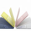 Una colección de fundas y protectores para laptop, incluyendo una funda amarilla, rosa y blanca.