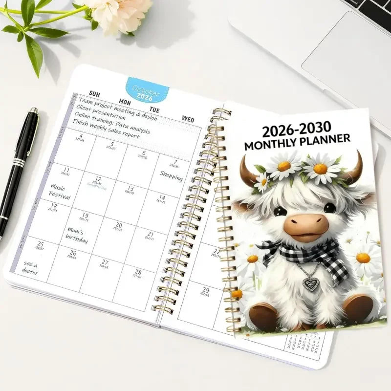 A spiral-bound monthly planner showing a June calendar page with weekly planning sections and a cute goat illustration.