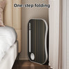 A sleek, folding laptop desk organizer tray in black and gold is shown next to a bed and curtains.