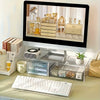 An acrylic keyboard stand for desktop organization featuring a monitor display and storage trays.