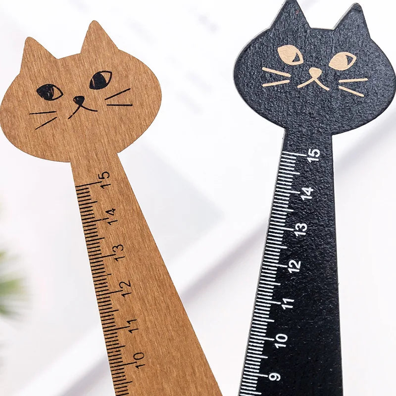 A wooden drawing ruler shaped like a cat, featuring a cartoon cat face and measurement markings.