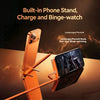 An orange phone stand accessory is shown holding a smartphone, demonstrating built-in charging and binge-watching features.