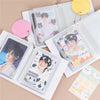 A clear binder holds various photo cards and a yellow circular tag for Kpop albums