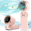 A pink portable handheld turbo fan with a circular grille is shown next to its charging base.