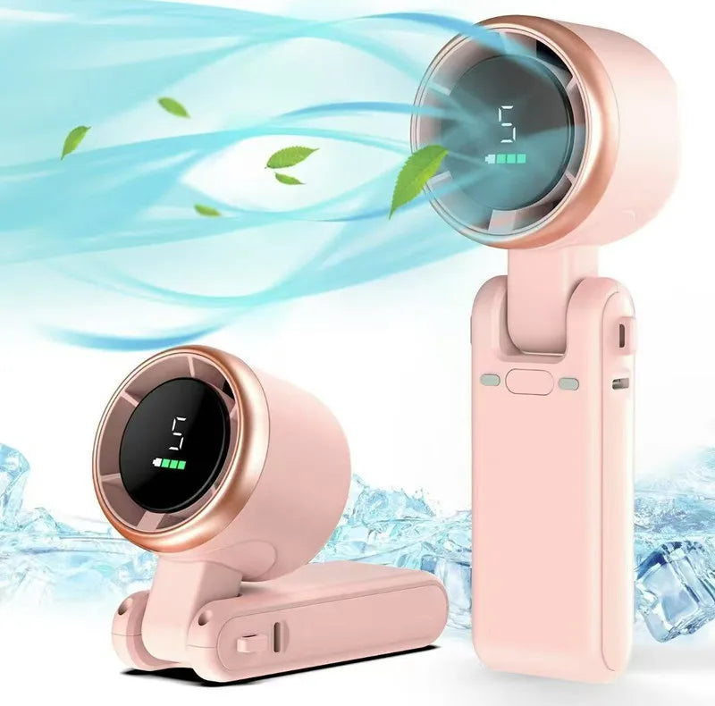 A pink portable handheld turbo fan with a circular grille is shown next to its charging base.