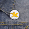 A yellow star enamel pin with the text your did it on a denim fabric background.