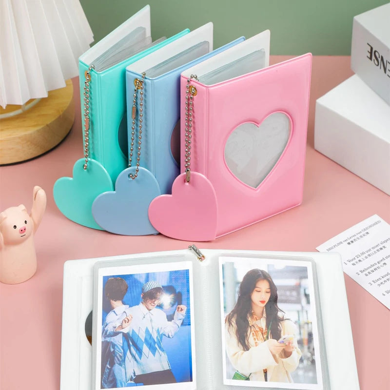 A pink hollow photo card binder with a heart design and a set of matching blue and teal binders.